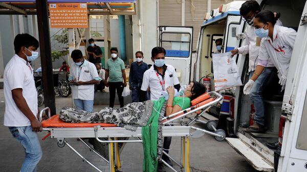 Пациента в кислородной маске везут в больницу для лечения COVID-19 в Ахмедабаде, Индия