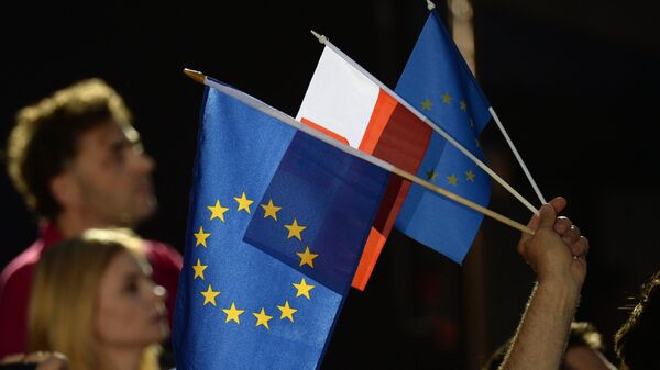 Люди с флагами Евросоюза и Польши в Варшаве