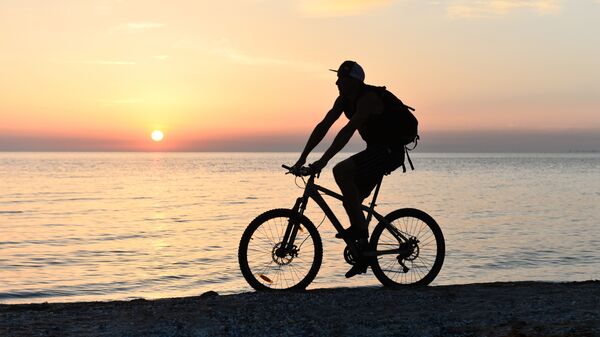 Велосипедист на берегу Азовского моря возле города Щелкино в Крыму
