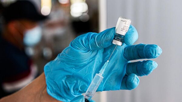 Медицинский сотрудник наполняет шприц однокомпонентной вакциной Спутник Лайт 