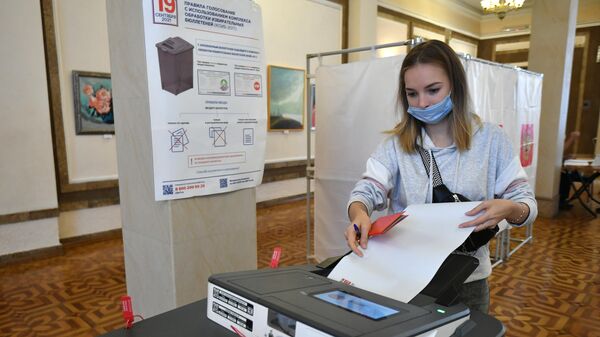 Избиратель на участке во время голосования на выборах депутатов Государственной Думы