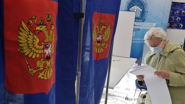 Избиратель голосует на выборах депутатов Государственной Думы РФ на участке в Санкт-Петербурге