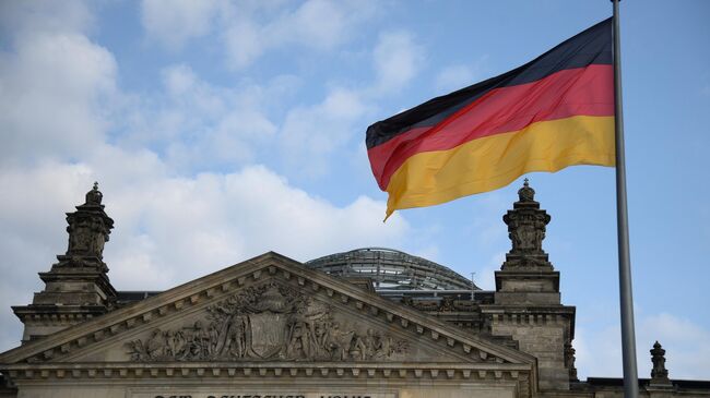 Национальный флаг Федеративной Республики Германия над зданием бундестага в Берлине. Архивное фото