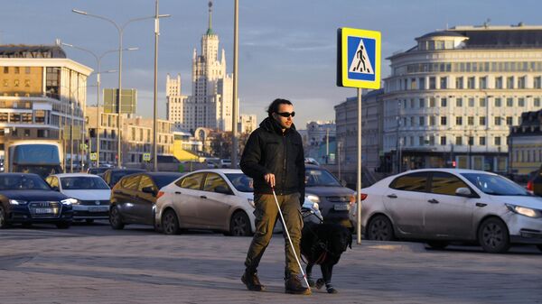 Мужчина переходит дорогу на одной из улиц Москвы