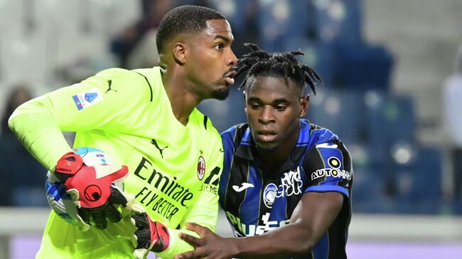 AC Milan's French goalkeeper Mike Maignan holds the ball back from Atalanta's Colombian forward Duvan Zapata during their Italian Serie A football match Atalanta Bergamo versus AC Milan at the Gewiss Stadium (Stadio di Bergamo) in the northern city of Bergamo on October 3, 2021. (Photo by MIGUEL MEDINA / AFP)