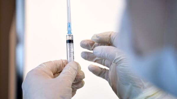 Медицинский работник держит в руках шприц с вакциной Гам-Ковид-Вак (Спутник V) 