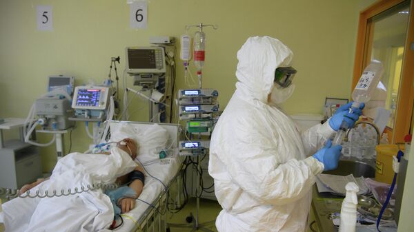 Медицинский работник и пациент c COVID-19 в отделении реанимации и интенсивной терапии в центральной клинической больнице РЖД-Медицина в Москве