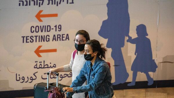 Девушки в защитных масках в аэропорту имени Бен-Гуриона, Израиль
