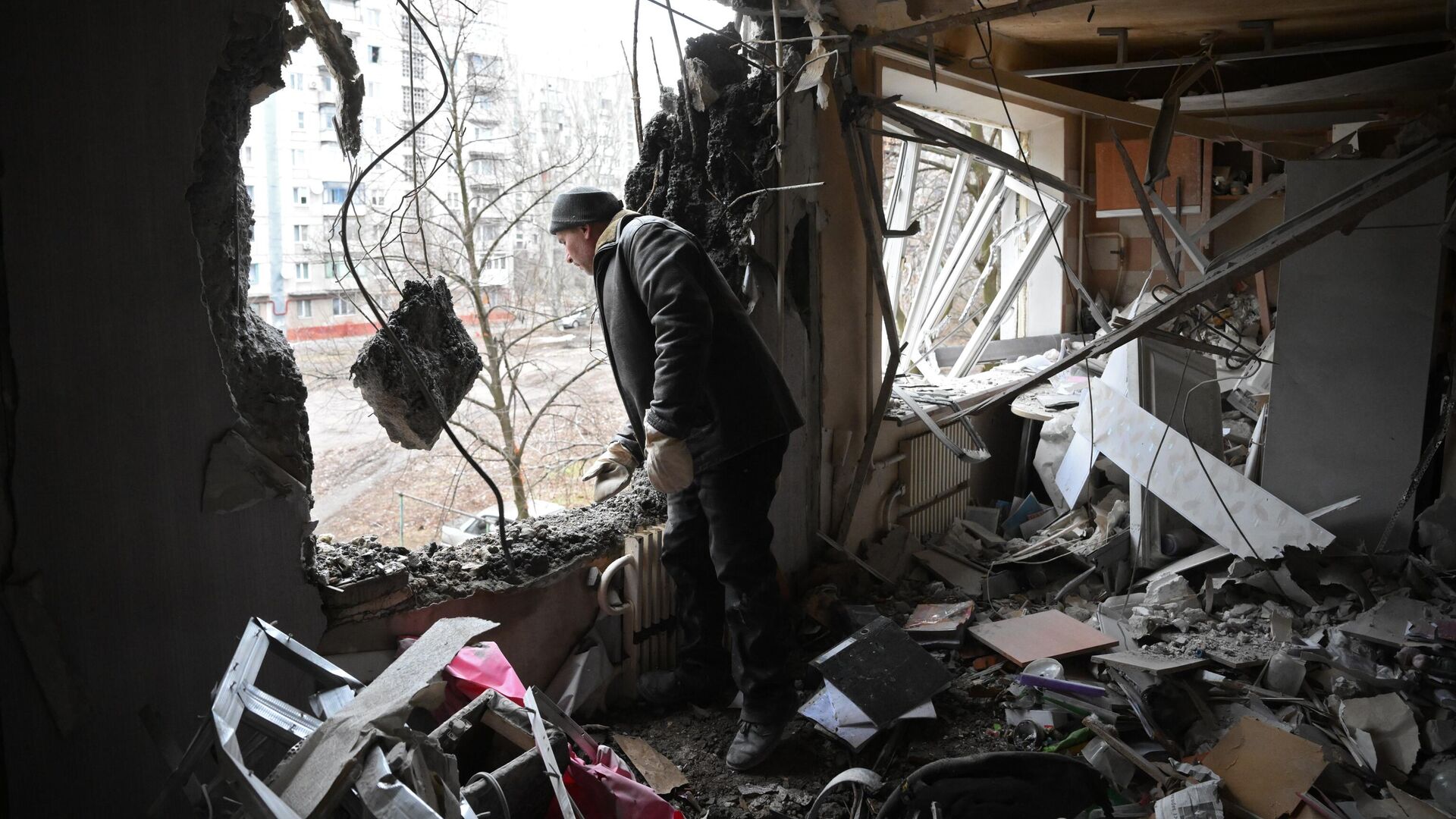 Мужчина в квартире, разрушенной в результате прямого попадания снаряда в жилой дом в Горловке - РИА Новости, 1920, 08.03.2022