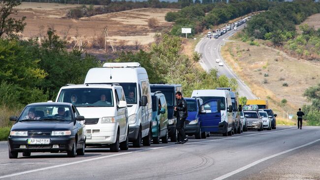 Автомобили в очереди у контрольно-пропускного пункта Васильевка в Запорожской области