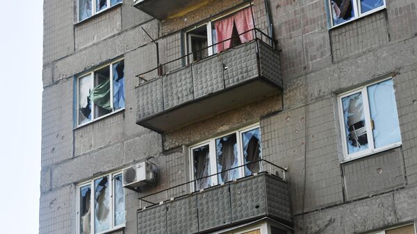 Выбитые стекла жилого дома в результате обстрела центральной части города Донецка