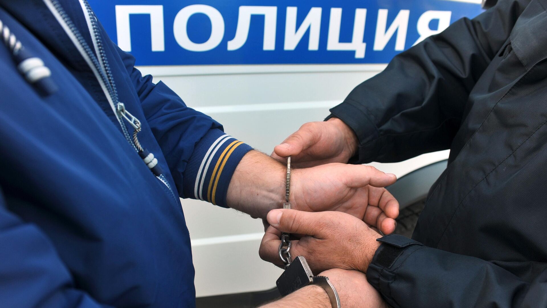 Сотрудник полиции надевает наручники на правонарушителя - РИА Новости, 1920, 16.12.2023