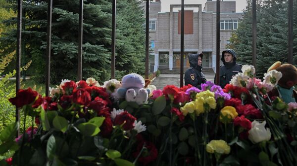 Сотрудники полиции у стихийного мемориала у школы № 88 в Ижевске