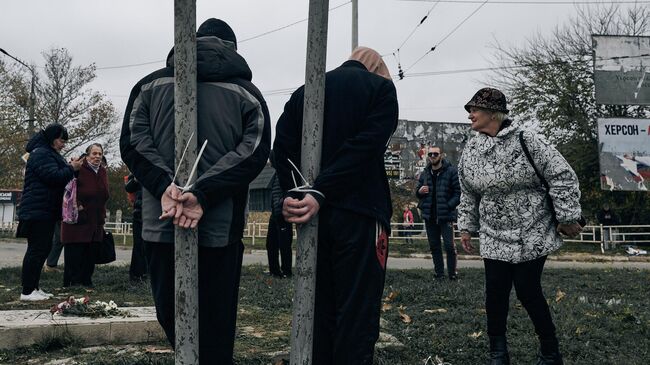 Жители Херсона, привязанные за руки к столбам на одной из улиц города