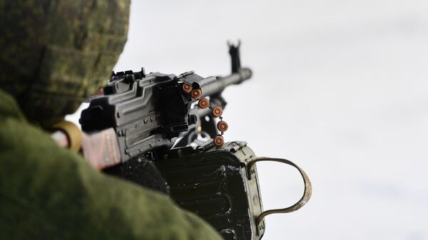 Военнослужащий стреляет из пулемета ПКМ 