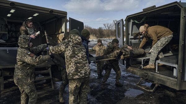 Медики транспортируют раненного украинского военного в районе Артемовска