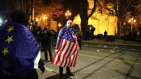 Мужчина с флагом США на протестах в Тбилиси, 9 марта 2023 года