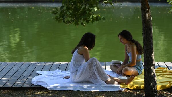 Девушки отдыхают в жаркую погоду в Парке Горького в Москве
