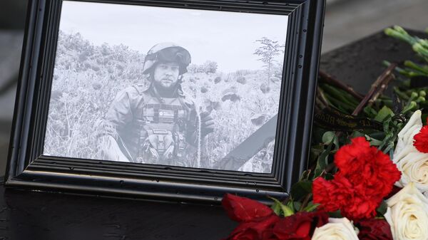 Фотография и цветы в память о военкоре Ростиславе Журавлеве