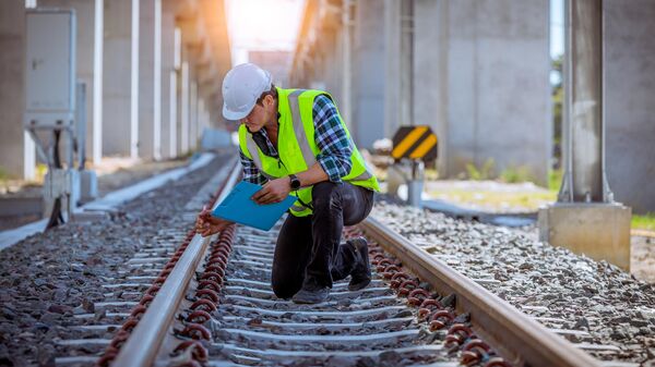 Инженер проверяет железнодорожные рельсы