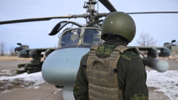 Военнослужащий группировки войск Центр ВС РФ подготавливает разведывательно-ударный вертолет Ка-52 к вылету для нанесения удара и выполнению боевых задач в зоне СВО