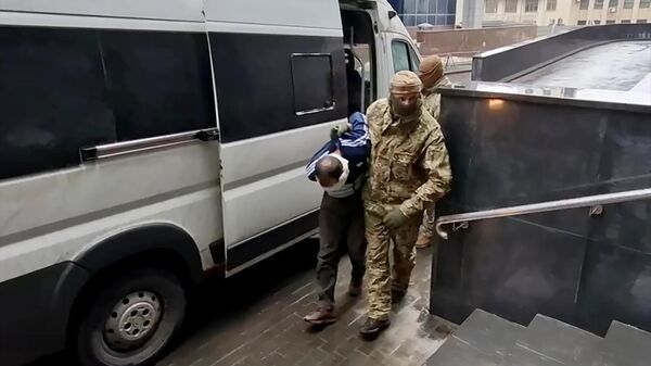 Один из задержанных по подозрению в террористическом акте в Крокус Сити Холл возле входа в здание центрального аппарата следственного комитета РФ в Москве. Стоп-кадр видео