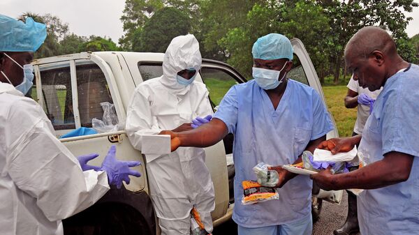 Медицинские работники передают средства индивидуальной защиты от лихорадки Эбола