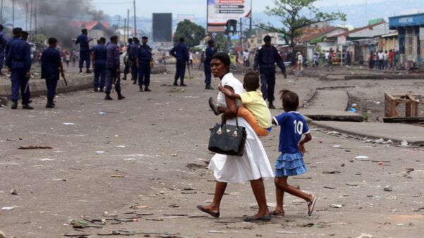 Семья на улице Киншасы во время столкновений представителей оппозиции и полиции
