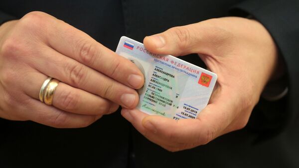 Заместитель председателя правительства России Максим Акимов демонстрирует образец электронного паспорта 