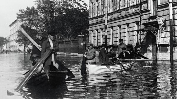Жители города, затопленного при наводнении, передвигаются по улицам в лодках