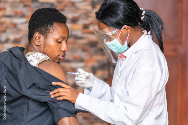 nurse administering vaccine to a male patient