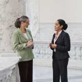 Descriptive image of people in front of a congressional building.