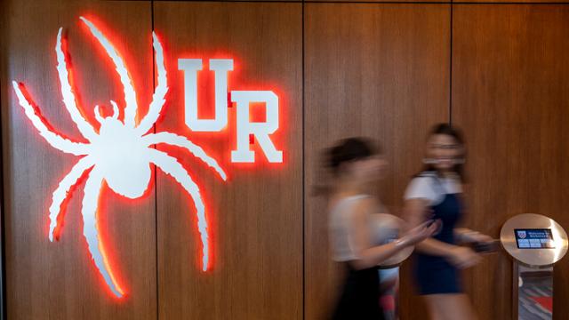 Red neon spider and UR sign in the Queally Center.