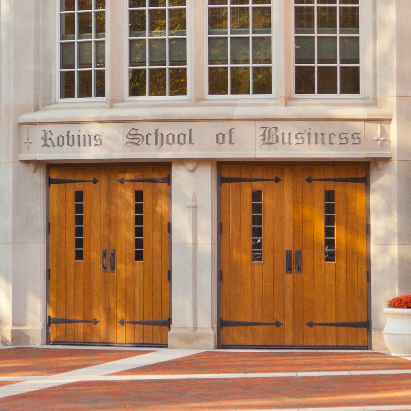 A student walks into the main entrance of the Robins School of Business.