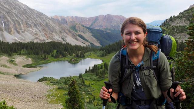 Smiling student hiking in the mountains.