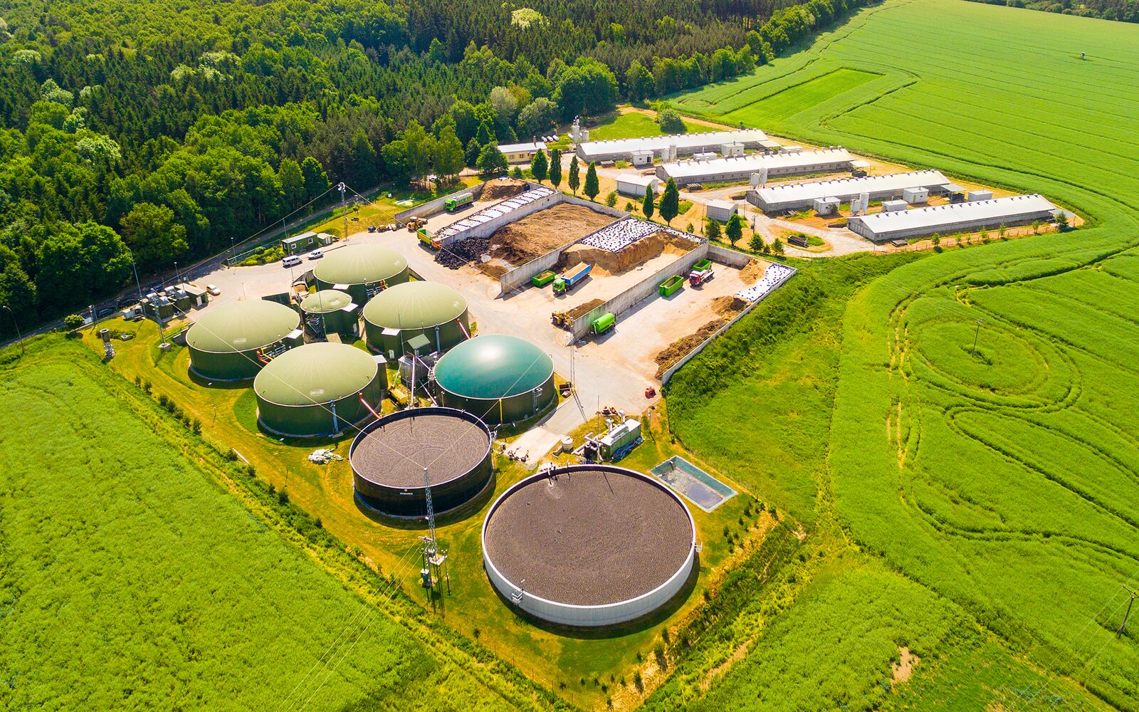 Aerial view over biogas plant and farm in green fields. Renewable energy from biomass. Modern agriculture in Czech Republic and European Union. ; Shutterstock ID 666196489; purchase_order: Main Visual; job: ; client: ; other: