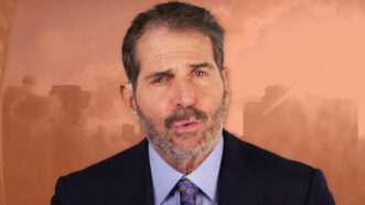 Photo of John Stossel overlaid on orange tinted skyline photo | Stossel TV