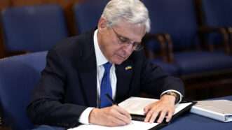 Attorney General Merrick Garland signs a document. | Abaca Press/Gripas Yuri/Abaca/Sipa USA/Newscom