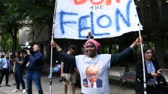 Protester holds "Don the Felon" sign outside NYC court house | Andrea Renault/Polaris/Newscom