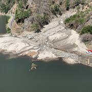 aerial photo of highway and river partially blocked by mud and debris