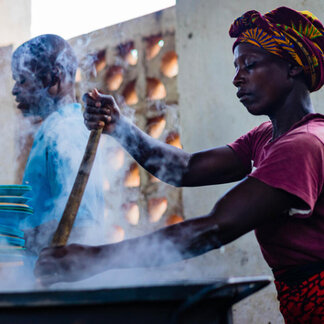 a woman and man are cooking food in a pot