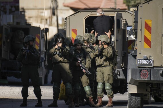 Israeli soldiers arrest a blindfolded Palestinian during an army raid in Tubas, West Bank, on Wednesday, Sept. 11, 2024. (AP Photo/Majdi Mohammed)