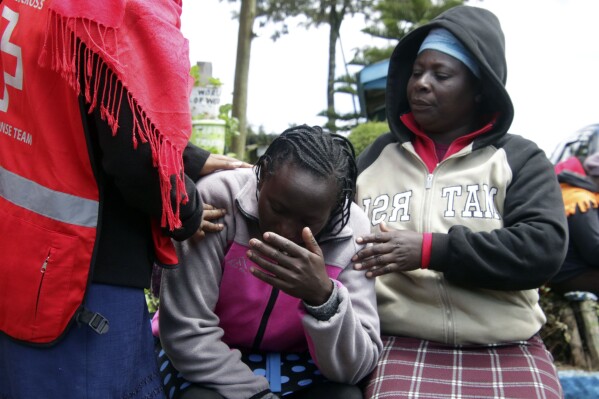 Kenya Red Cross personnel and relatives try to comfort a woman reacting near a burned-out dormitory, following a fire at the Hillside Endarasha Primary in Nyeri, Kenya Friday, Sep. 6, 2024. (AP Photo)