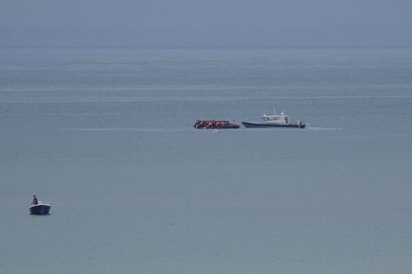 A boat thought to be with migrants is escorted by a vessel from the French Gendarmerie Nationale off the Wimereux beach, France, Wednesday, Sept. 4, 2024. A boat carrying migrants ripped apart in the English Channel as they attempted to reach Britain from northern France on Tuesday, plunging dozens into the treacherous waterway and leaving 12 dead, authorities said. (AP Photo/Nicolas Garriga)