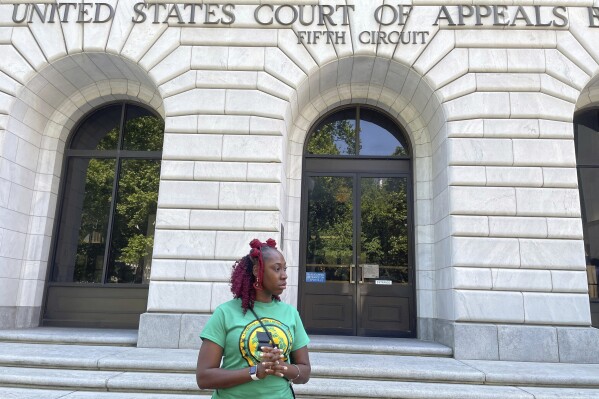 FILE - Teliah Perkins stands in front of the federal appeals court building in New Orleans, May 3, 2023, following a hearing on her lawsuit against two St. Tammany Parish, La., sheriff's deputies stemming from her arrest in May 2020. A teenager who video-recorded his mother Teliah's forceful arrest by Louisiana sheriff's deputies has been awarded $185,000 by a federal jury in a lawsuit filed over one deputy's attempt to interfere with the recording. (AP Photo/Kevin McGill, File)