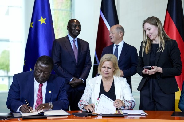 German Interior Minister Nancy Faeser, down right, signs a migration agreement with Kenyan's Prime Cabinet Secretary Musalia Mudavadi, left, as German Chancellor Olaf Scholz, centre behind, and Kenyan President William Ruto, left behind, at the chancellery in Berlin, Friday, Sept. 13, 2024. (AP Photo/Ebrahim Noroozi)