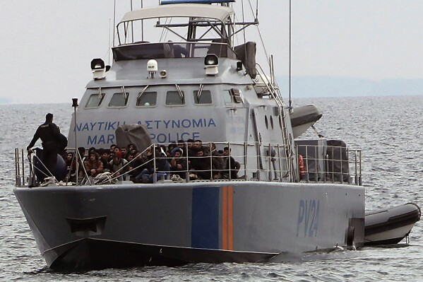 FILE - Migrants aboard a Cyprus marine police patrol boat as they're brought to a harbor after being rescued from their own vessel off the Mediterranean island nation's southeastern coast of Protaras, Cyprus, on Jan. 14, 2020. (AP Photo/Petros Karadjias, File)