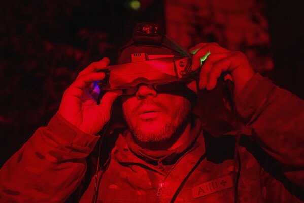 A Ukrainian serviceman of the ACHILLES battalion of the 92nd brigade operates a suicide drone over Russian positions in the Kharkiv region, Ukraine, Sunday, May 12, 2024. (AP Photo/Evgeniy Maloletka)