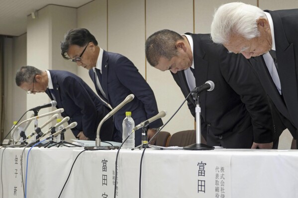 Shinji Kaneko, second left, President of Keikyu Department Store Co. bows during a press conference in Yokohama, south of Tokyo, Monday, July 29, 2024. About 150 people have been sickened by food poisoning after eating a Japanese summertime delicacy, grilled eel, prepared by a restaurant chain and sold at the department store near Tokyo, leaving one person dead and two others hospitalized, officials said. (Kyodo News via AP)