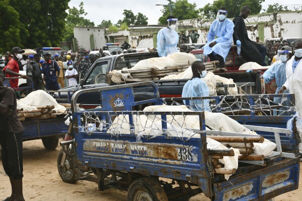 Bodies of people killed by suspected Boko Haram Islamist extremists are transported for burial, in Tarmuwa, northeast Nigeria, Tuesday, Sept. 3, 2024. (AP Photo/Michael Abu)